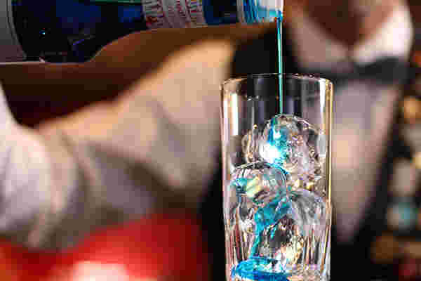 グラスにブルーハワイシロップを注ぐ