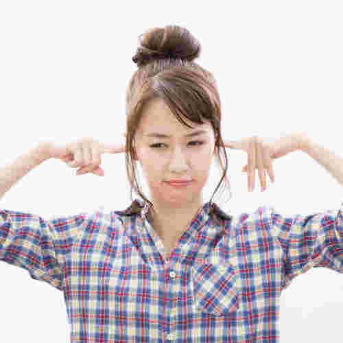 耳をふさぐ女性