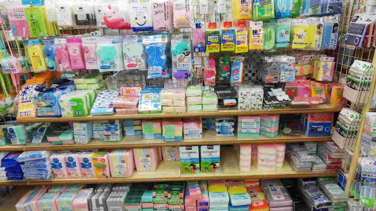 100円ショップにある何段もの棚に陳列された色んな形や色をした複数のスポンジ