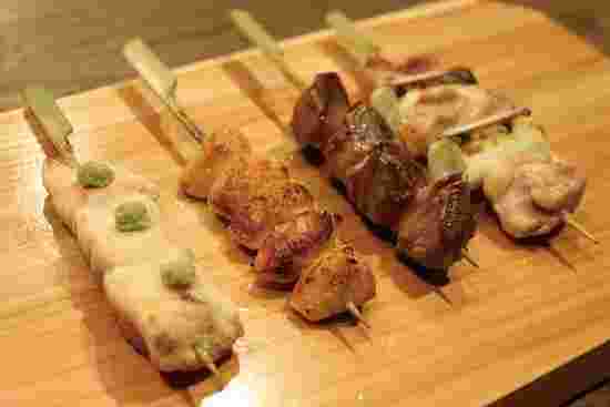 様々な種類の焼き鳥が木の板にのっている写真