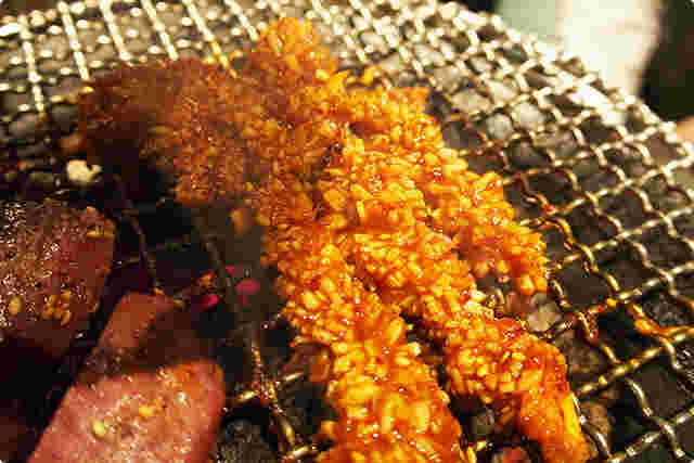 二種類の肉が網の上で焼かれている様子。