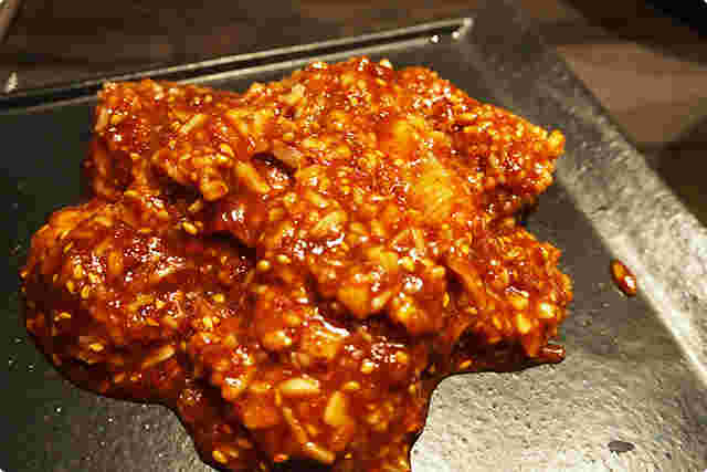 タレに漬けた肉が皿の上に盛られている様子。