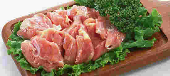 鶏モモ肉を木のプレートに盛り付ける