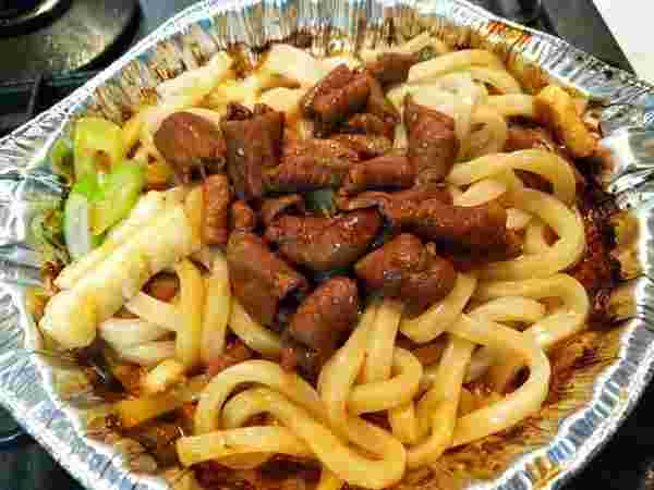 銀皿に盛られた焼きうどんとモツ
