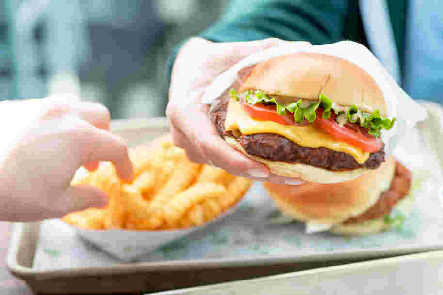 シャックバーガーをつかんでいる