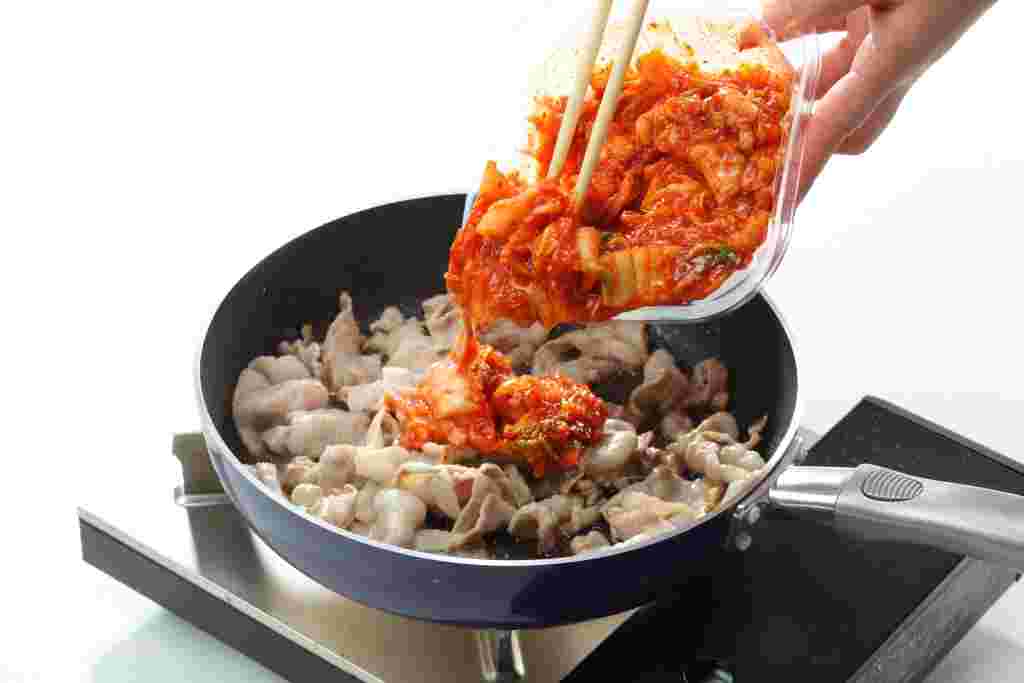 フライパンに豚バラ肉とキムチを入れて炒める