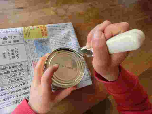 貯金箱の缶を開ける様子