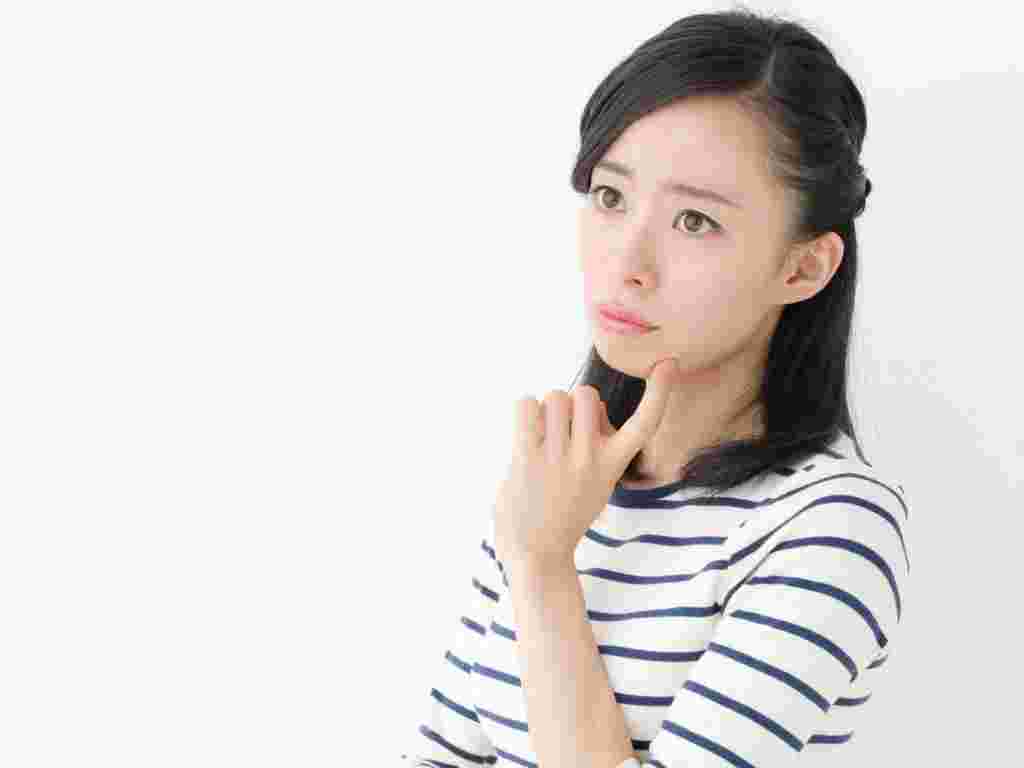 人差し指を顎に当てて困り顔の女性