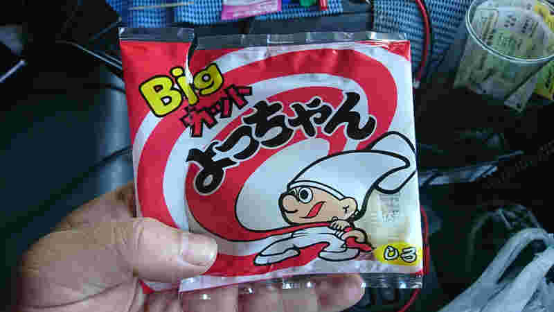 ビッグカットよっちゃんしろのパッケージを左手で持つ人