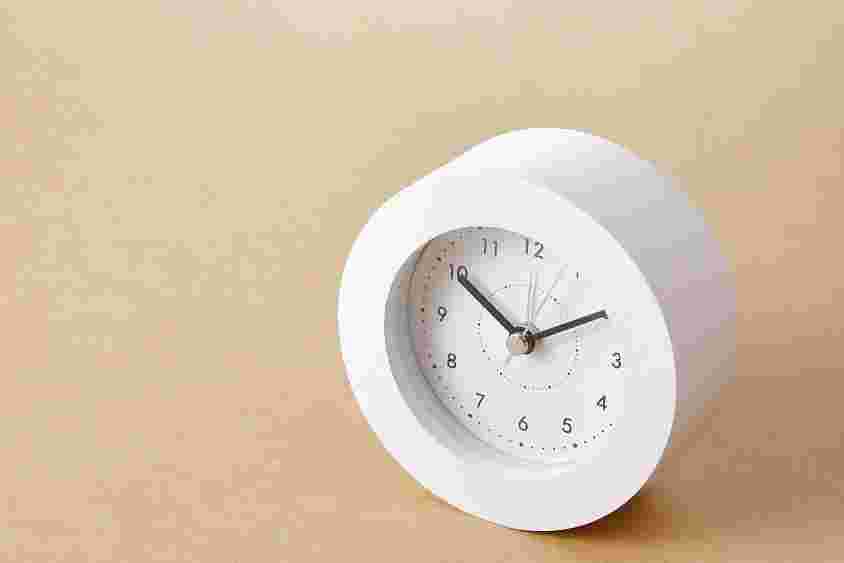 テーブルの上に白い時計が置かれている様子。