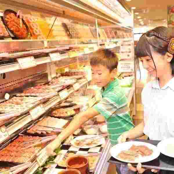 子供たちが焼肉バイキングコーナーで肉類を選んでいる様子