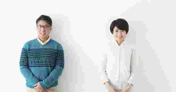 大人の男性と女性が少し距離をおいて白い壁に並んで立っている様子。