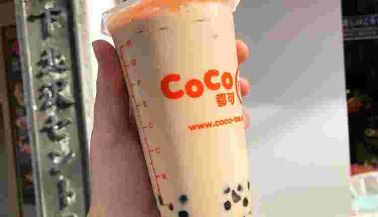 CoCo都可のタピオカミルクティーを手に持っている