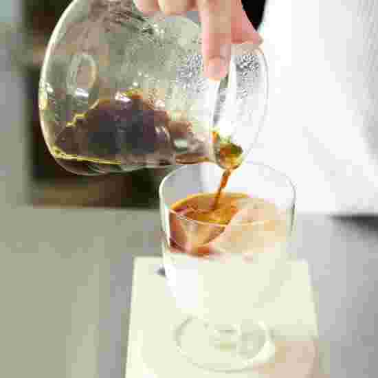 グラスに入ったミルクにコーヒーを注ぐ様子