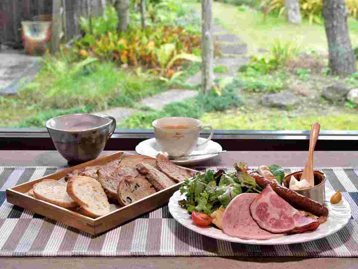 温かい飲み物と数個のパン、具材が揃えているところ。