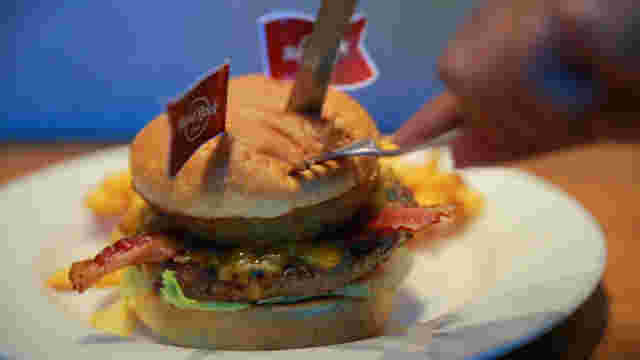 ピックの刺さったハンバーガーをカットしている