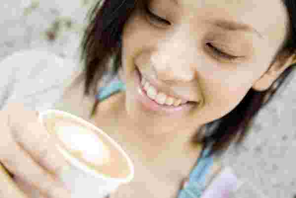 女性が飲み物を持っている様子。