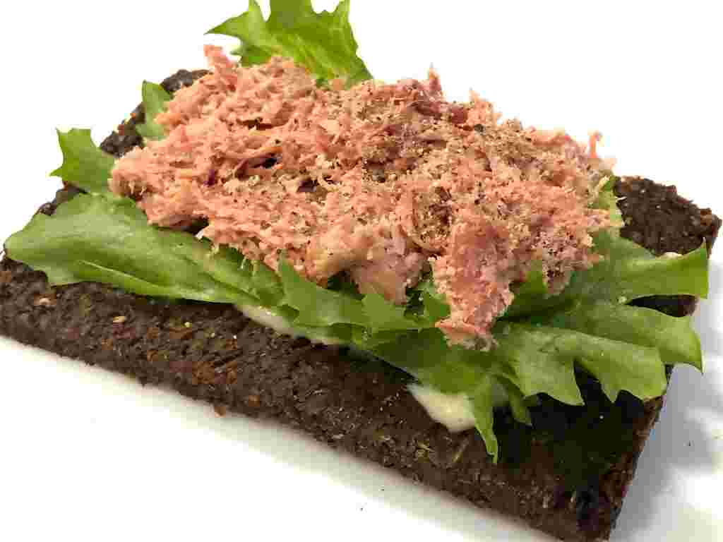 プンパニッケルにコンビーフ、レタスを乗せている様子