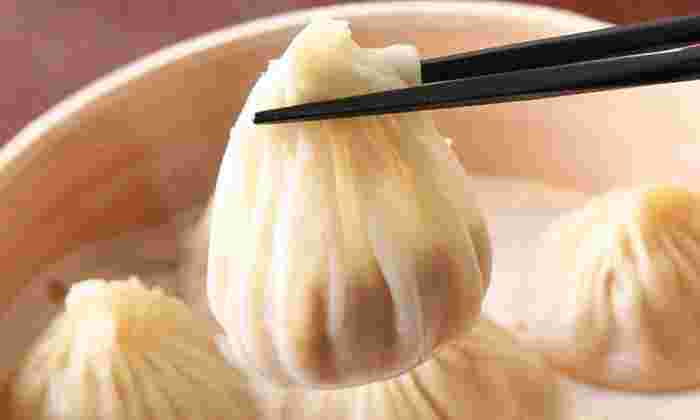 小籠包を箸でつまんでいる