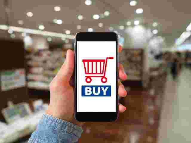 左手で持ったスマホにBUYに文字