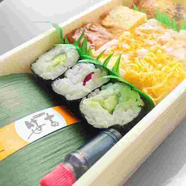 巻き寿司と食べ物が箱に入っている様。