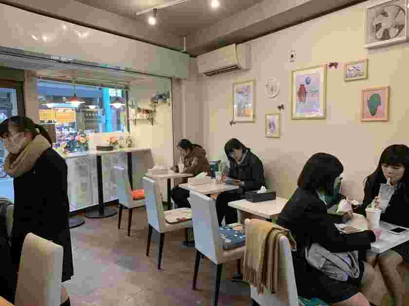 テーブルを囲って4人の女性が飲み物を飲んでいる様子。