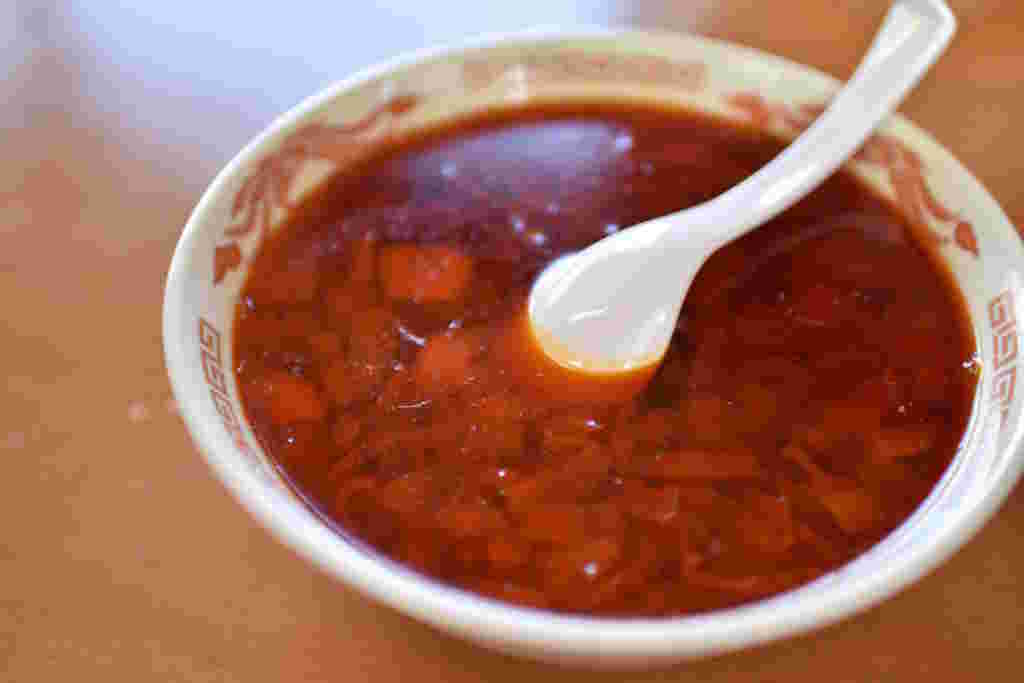 醤油スープにラー油を加えている様子