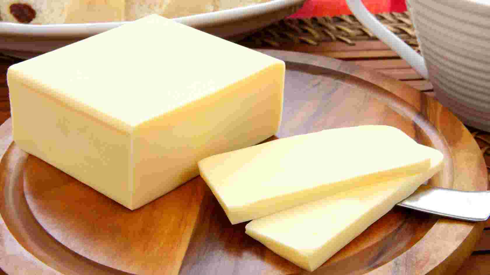 木のお皿の上に薄くカットされたバターと塊になったバターを乗せている様子
