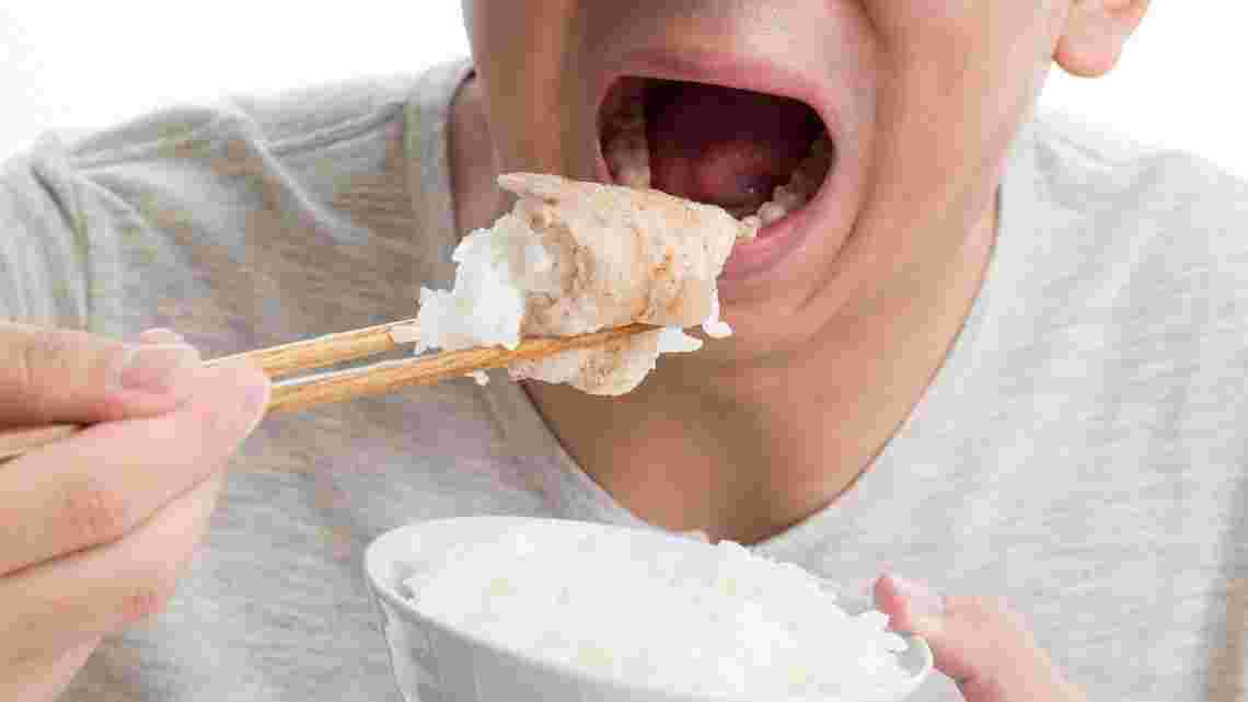 お肉とご飯を食べる男性