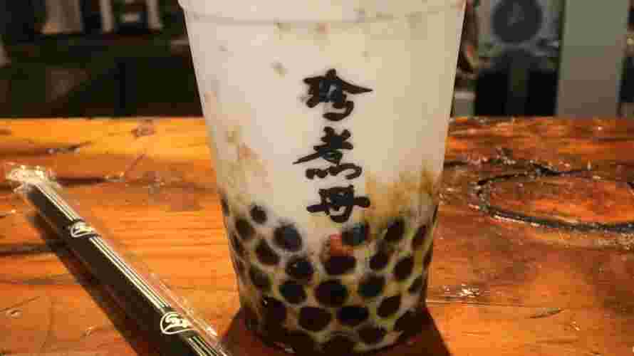 木彫のカウンターに飲み物とストローが置かれている様。