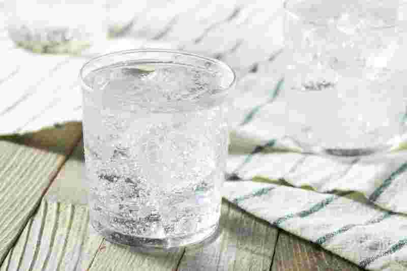 炭酸水を氷の入ったグラスに注ぐ