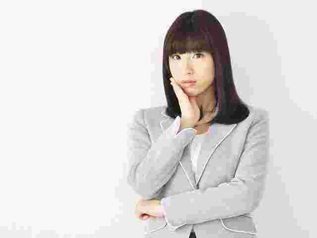 手を顎に当て考えこむ表情の女性
