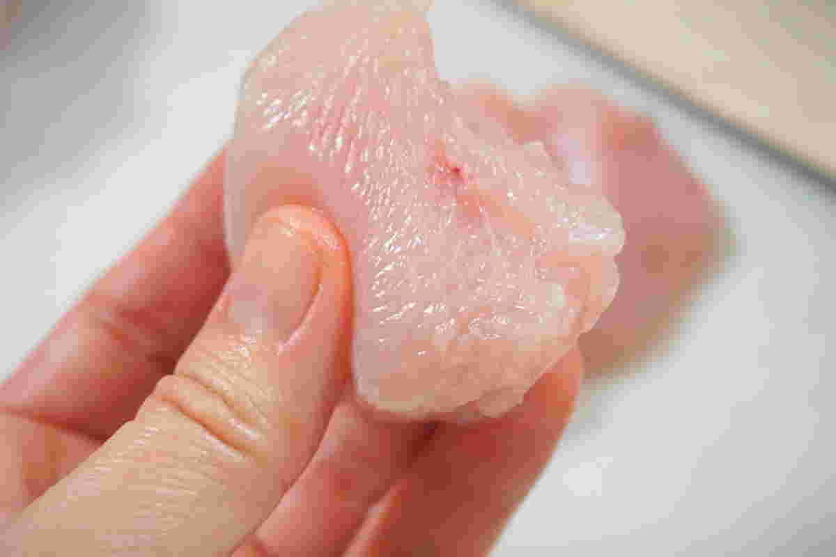一口大にカットしたとりむね肉を手に取る