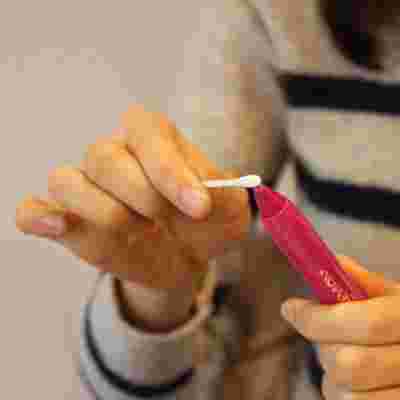 赤色のクレヨンの先っちょに綿棒を押し当てている様子