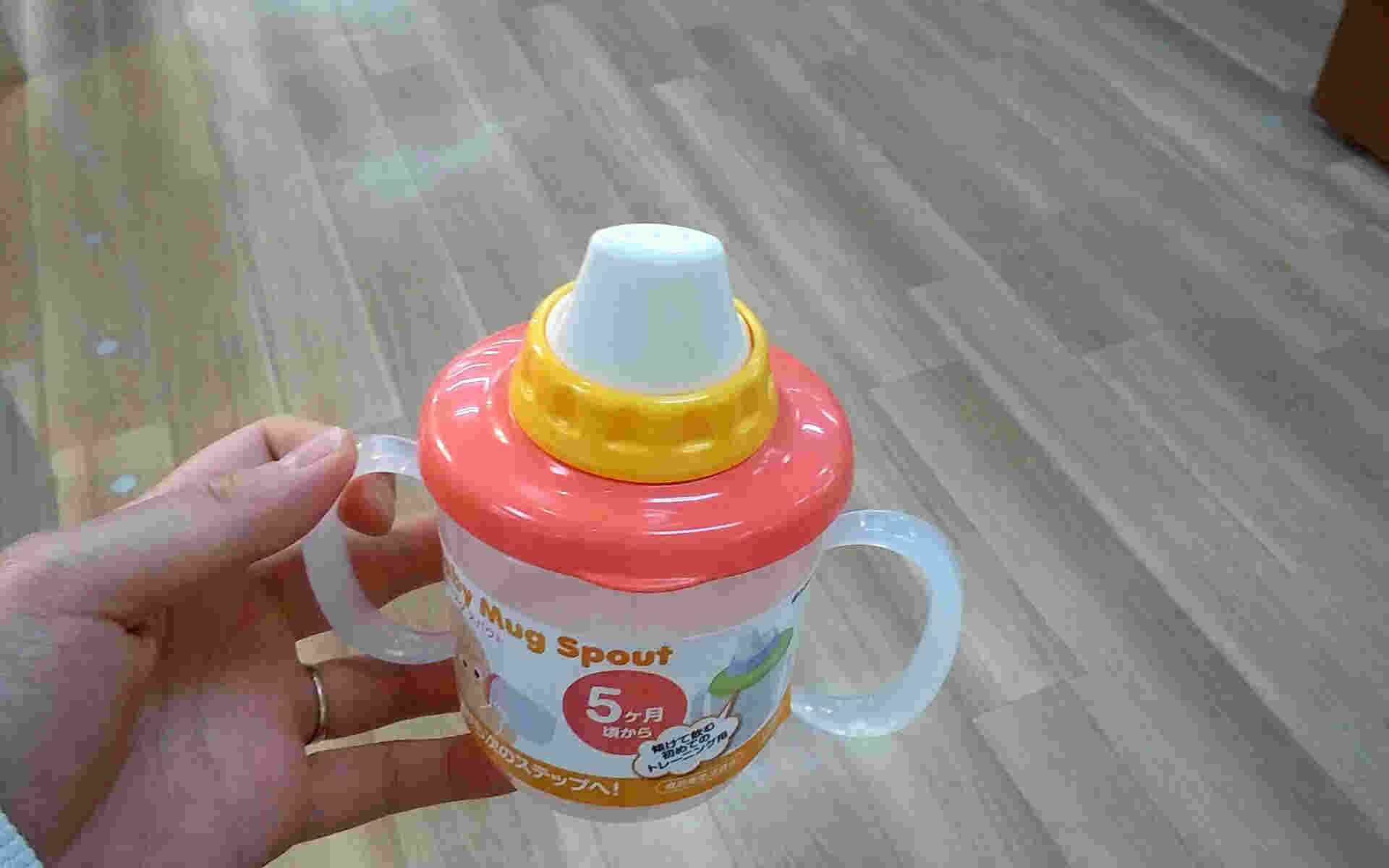 左手でベビーマグを持っている様子