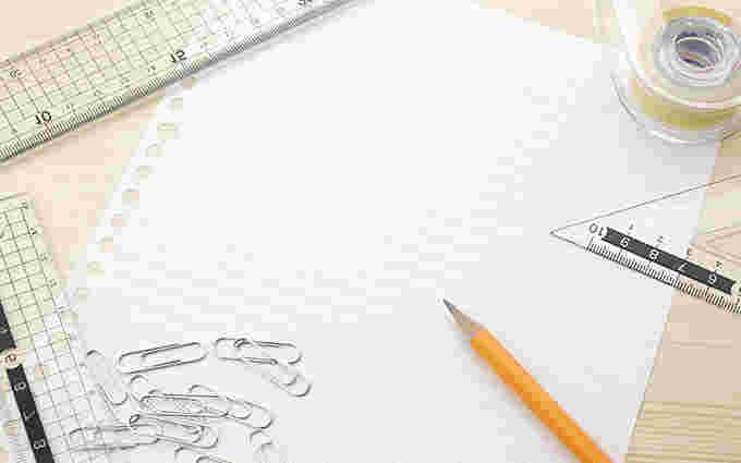 ルーズリーフと鉛筆、クリップなどが散らばっている