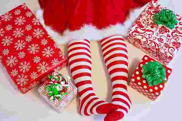 クリスマスにちなんだコスチュームを着る女の子とクリスマスプレゼントを並べる