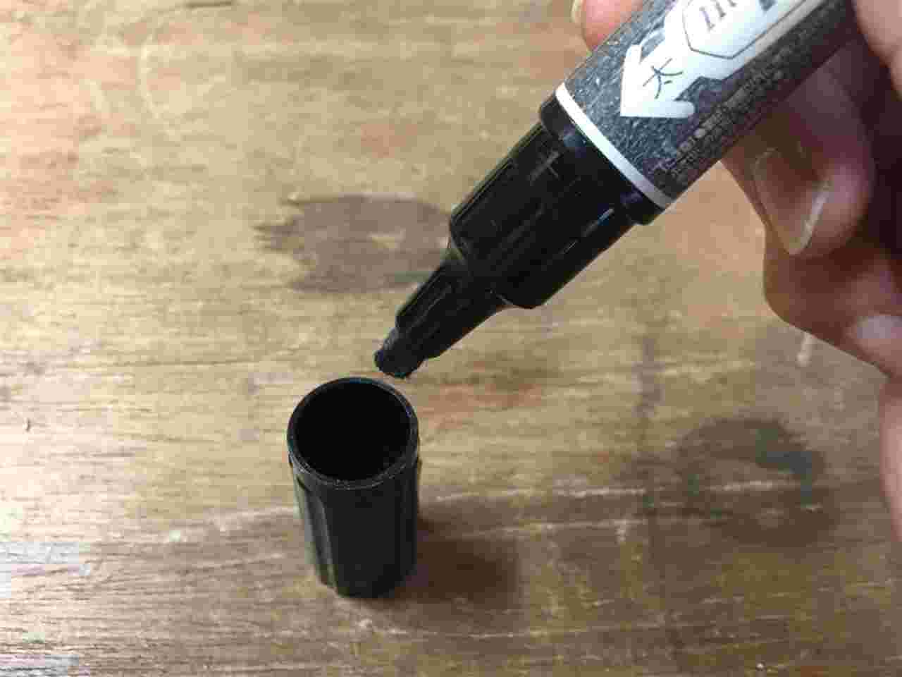 除光液を浸したキャップに油性ペンを入れるところ