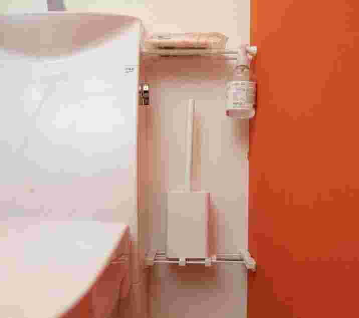 突っ張り棒を使ってトイレブラシとケース、スプレー、ウエットシートを収納する