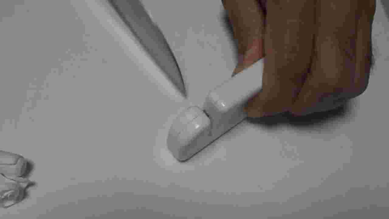セリアの包丁研ぎ器と包丁を手に持っている様子