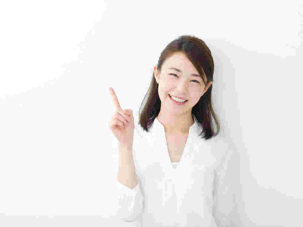 人差し指をさしてポイントを示す笑顔の女性