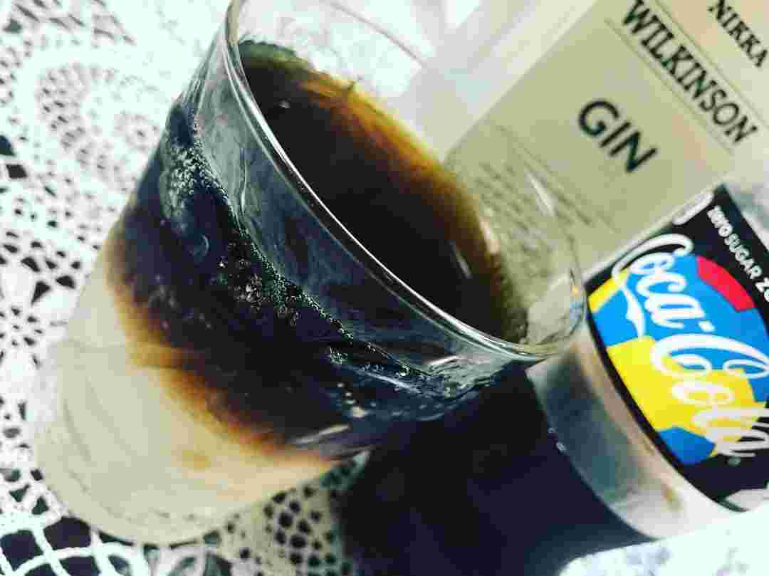 グラスの中でジンとコーラが二層に分かれている