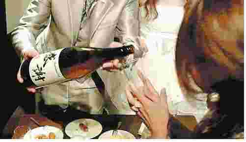 一升瓶でお酒を注いでいる様子