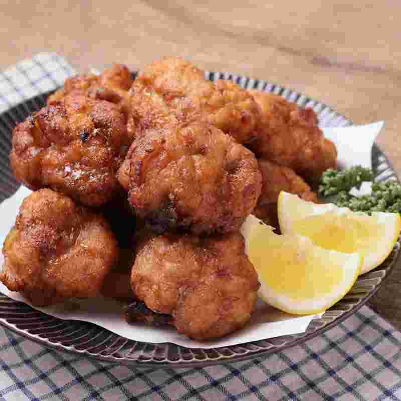 カラッと軽い米粉の衣で揚げた唐揚げを皿に盛り付ける