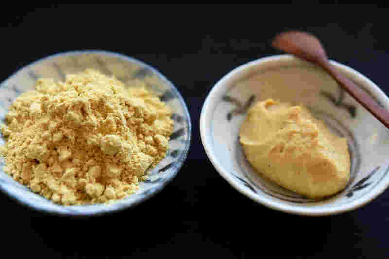 左側に豆皿に入った和がらし粉、右側に白い器に入った練り辛子