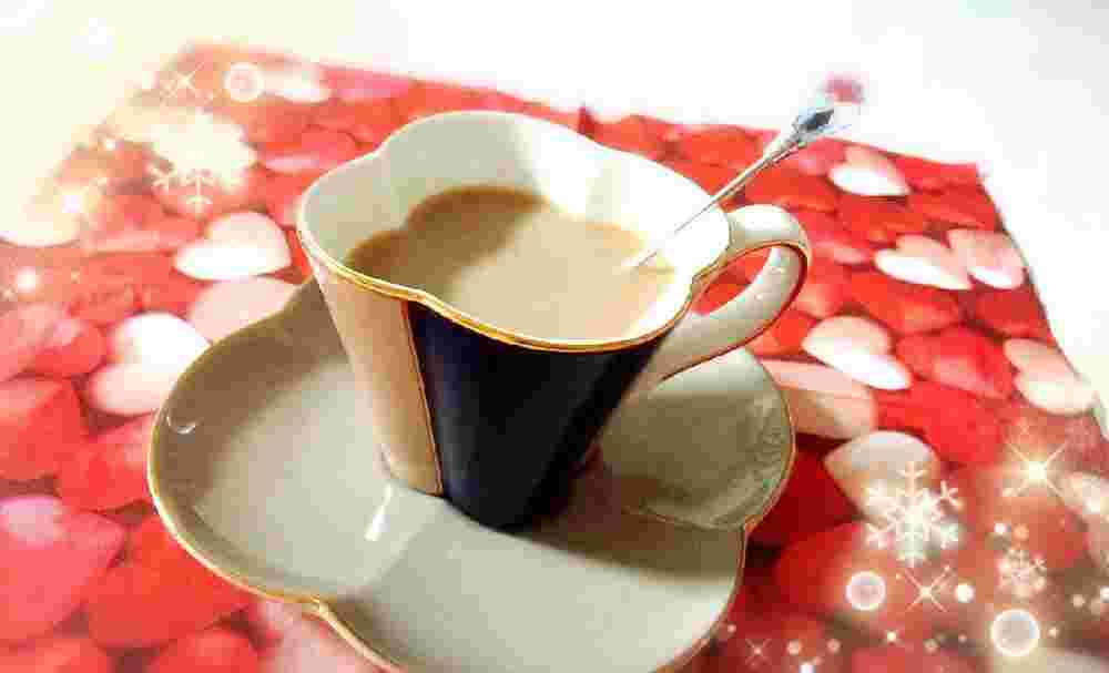 ハートのクロスの上に、黒糖豆乳コーヒーが注がれた花の形をしたカップが置かれている