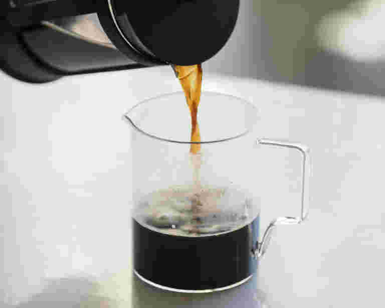 ドリップしたコーヒーをグラスに注いでいる