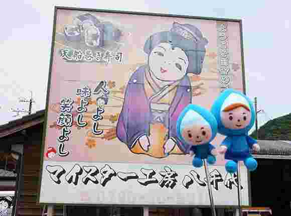女性の絵と巻きずしの写真が載った看板