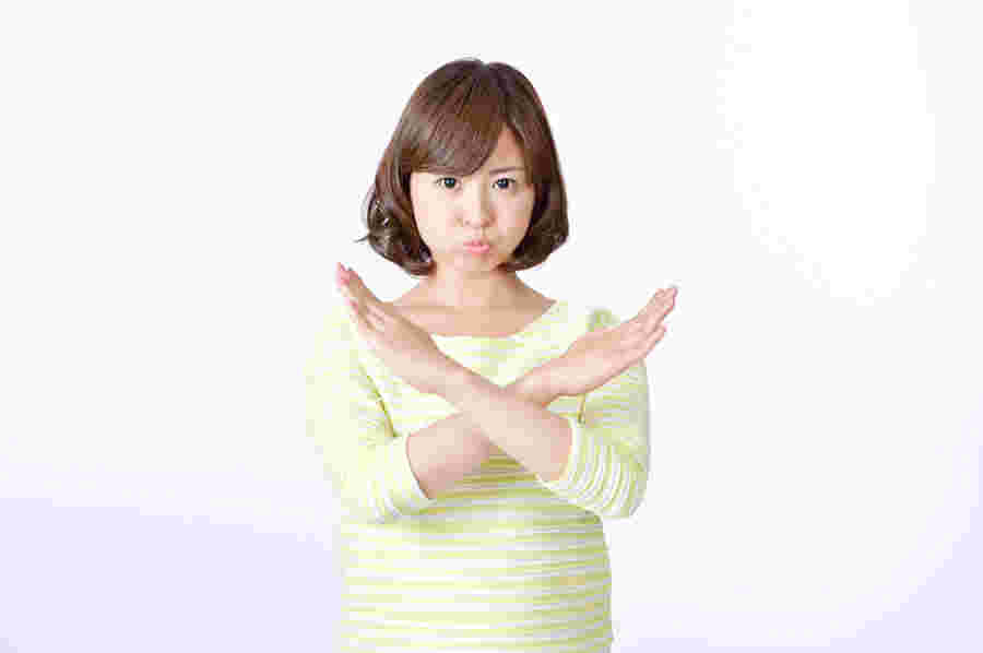 女性が手を重ねてバツのポーズをしている