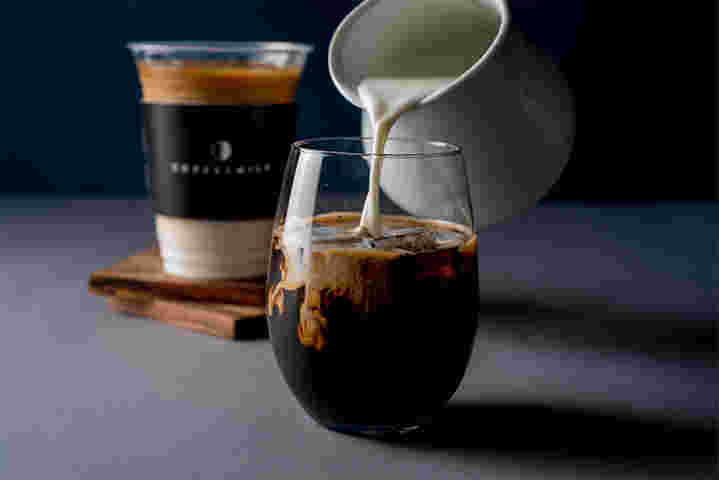 コーヒーにミルクを注いでいる様子